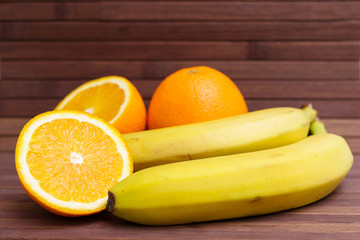 Fresh fruits banana, orange isolated on wooden background. Healthy food. A mix of fresh fruit. Group of citrus fruits. Vegetarian raw fruit. Nutrition for a healthy lifestyle.