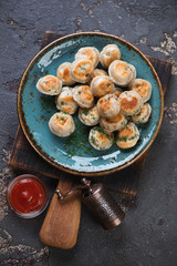 Roasted russian pelmeni, above view on a brown stone background, studio shot