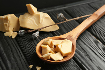 Wooden spoon with cocoa butter on table