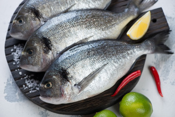 Close-up of fresh uncooked sea beams on a wooden chopping board, close-up, horizontal shot