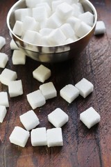 White sugar cubes  on wooden background
