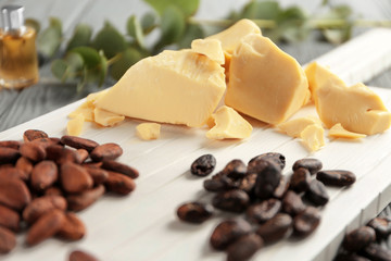 Cutting board with cocoa butter and beans, closeup