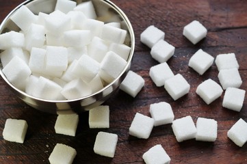 White sugar cubes  on wooden background
