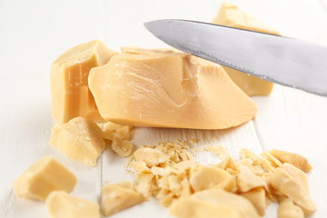 Cocoa butter and knife on wooden background