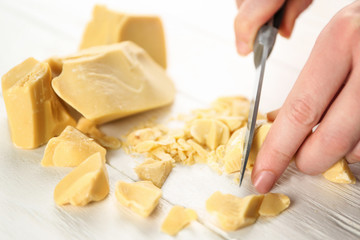 Female hands cutting cocoa butter, closeup