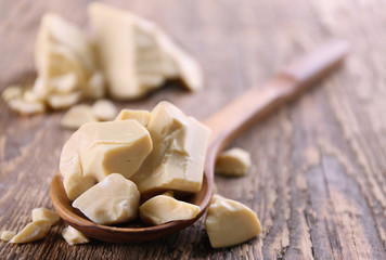 Wooden spoon with cocoa butter on table