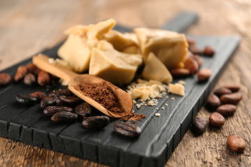 Cocoa butter, powder and beans on wooden board