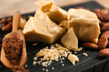 Cocoa butter, powder and beans on wooden board