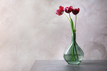 Vase with beautiful tulips on table
