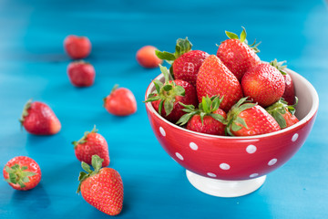 Ripe red strawberries on blue wooden table, Fresh strawberry, Strawberries in white bowl.