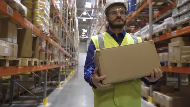 Warehouse worker takes box from rack
