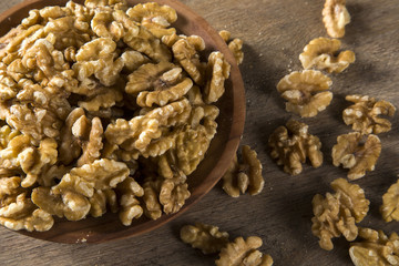 walnuts in wood bowl on wood table.