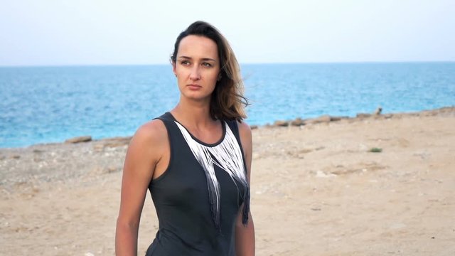 Pensive, sad woman standing on beach near sea, super slow motion 240fps
