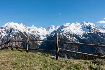 Blick über den Holzzaun in die Alpen