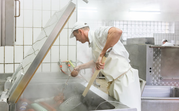 Fleischer kocht W&uuml;rste im Kessel und stellt so Br&uuml;hwurst her