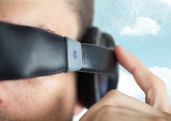 Close up of VR headset on man against sky