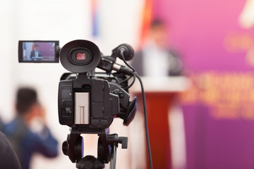 Filming an media event with a video camera. Press conference.