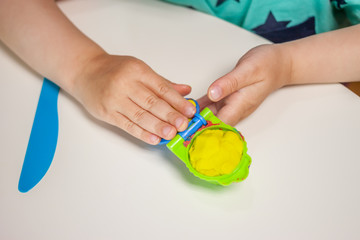 child hands playing with plasticine