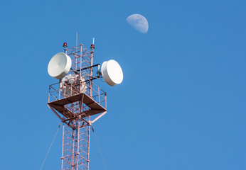 Fototapeta na wymiar Radio antenna tower over blue sky and moon