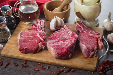 Raw fresh meat rib eye steak composition on wooden background