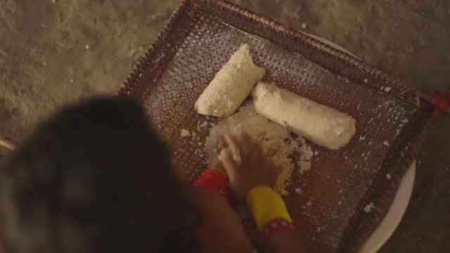 Indigenous woman crushing manioc for dinner