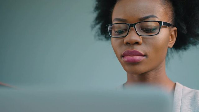 Beautiful african american business woman wearing glasses working with laptop computer at the office