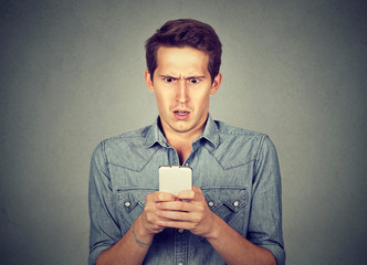 Shocked man checking mobile phone