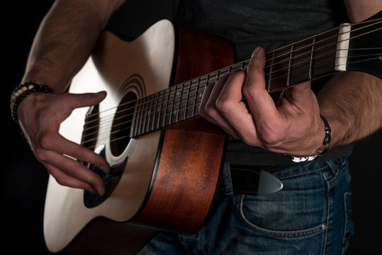 Playing guitar. Acoustic guitar in the hands of the guitarist. Horizontal frame