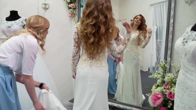 girlfriends chooses wedding gown at boutique