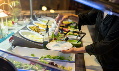 woman hands holding tweezer and dish rocket salad
