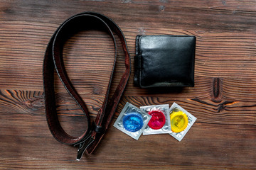 male contraception for safe sex with condoms and wallet on wooden background top view