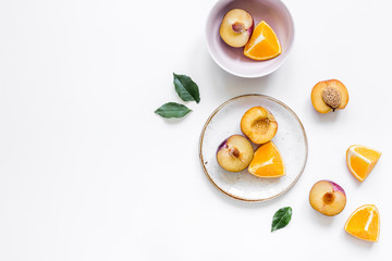 tropical peach and orange fruits for fresh juice on plates white background top view space for text