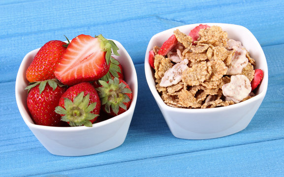 Fresh strawberries, wheat and rye flakes in bowl on boards, healthy lifestyle and nutrition
