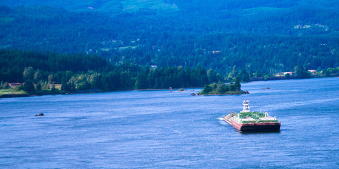 Naklejka premium Small tug pushing huge barge Columbia River scenic Columbia Gorge