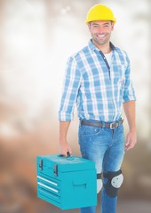 Construction Worker with tool box in front of construction site