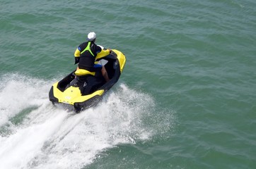 Running waves inn a yellow jet ski on the florida intra-coastal waterway .
