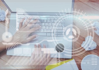 Hands of woman working on a laptop with digital graphics