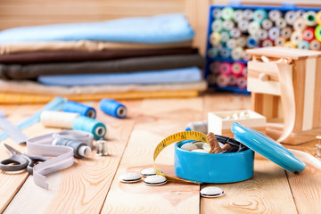 Accessories to sewing - fabric, a thread and a button. Selective focus. Copy space