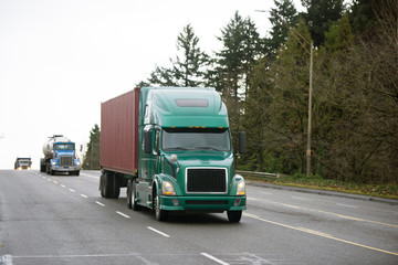 Different models of Semi trucks convoy on wide multiline road