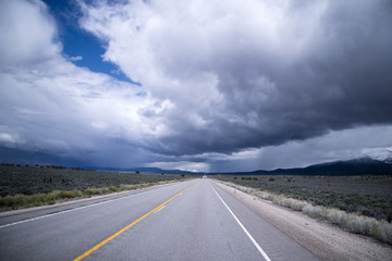 Storm clouds and endless staight road in Nevada