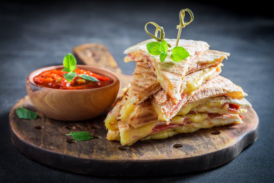Spicy quesadilla made of tortilla with sauce and herbs