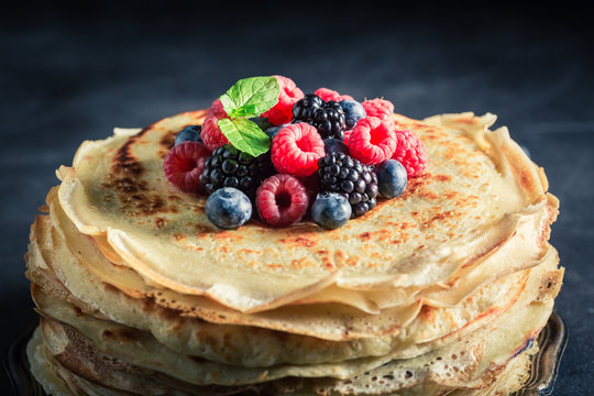 Delicious pancakes cake with fresh berries and mint