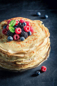 Sweet pancakes cake with berries and powder sugar