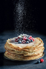 Tasty stack of pancakes with berries and powder sugar