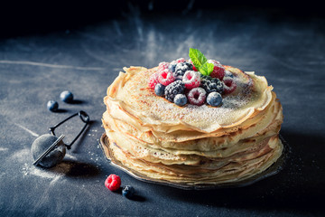 Delicious stack of pancakes with berries and powder sugar