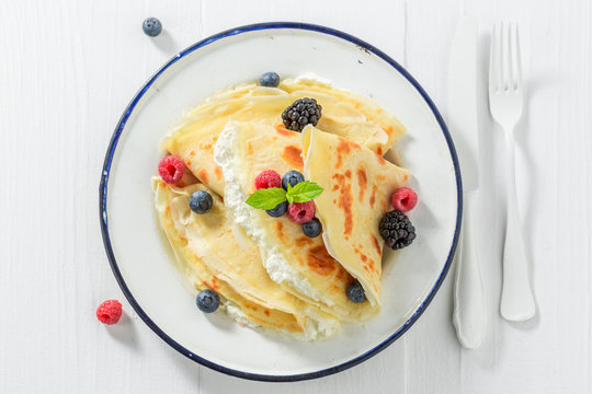 Homemade pancakes with curd and berries and powder sugar