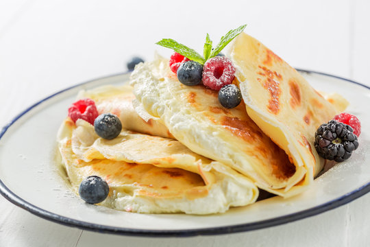 Tasty pancakes with cottage cheese and berries and powder sugar