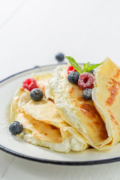 Tasty pancakes with curd and berries and powder sugar