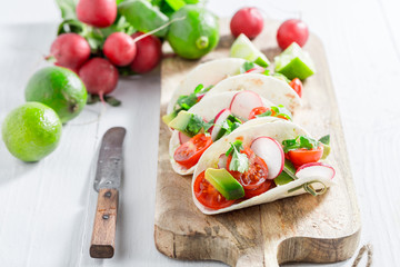 Tasty tacos with fresh vegetables and lime