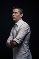 Fototapeta premium one young man, side view, looking tense, black background